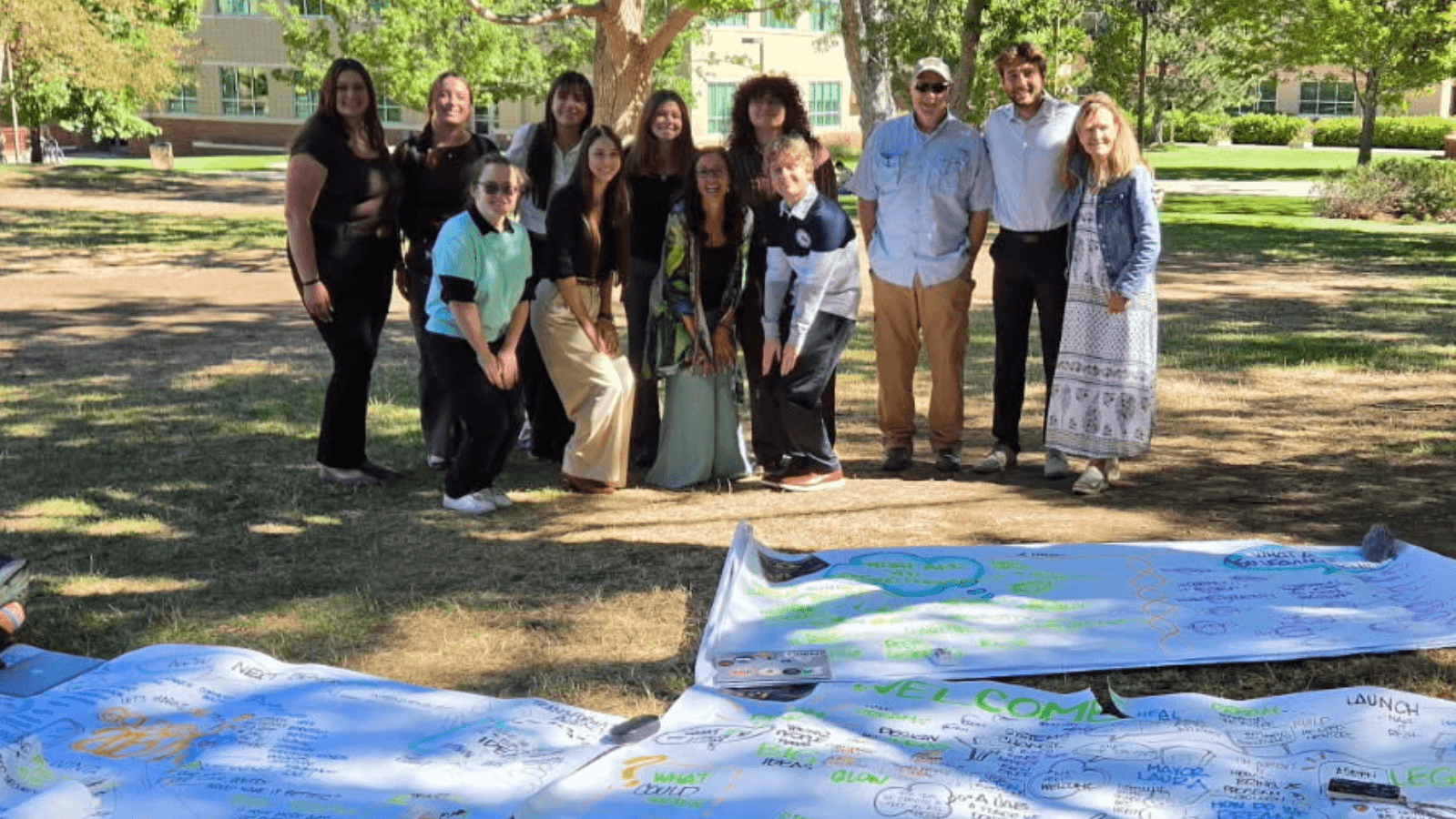 The Mines capstone Dream Team on campus at kickoff, standing over the systems map painted live on August 7.